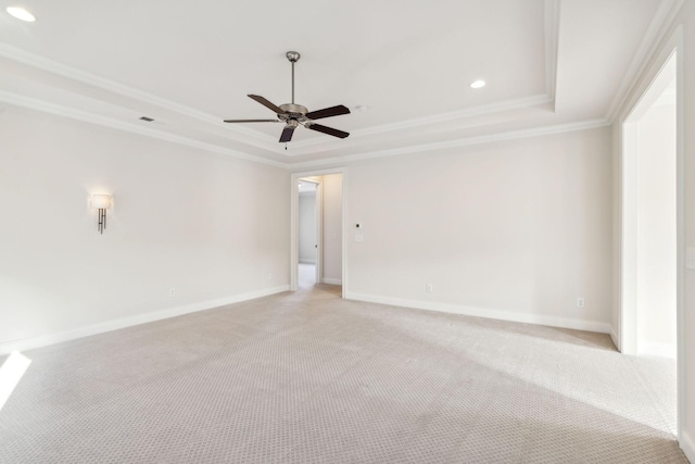 carpeted spare room with ceiling fan, ornamental molding, and a raised ceiling