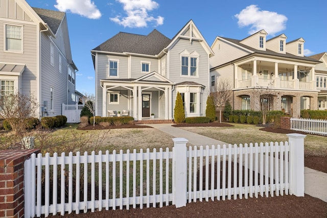 view of front facade with a porch, a balcony, and a front yard