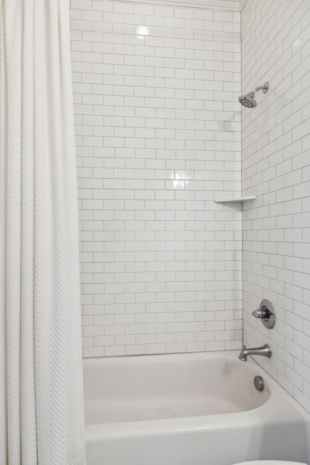 bathroom featuring shower / bath combination with curtain and toilet