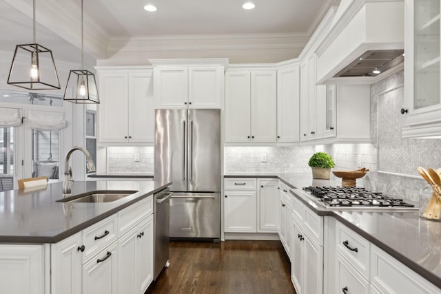 kitchen featuring pendant lighting, sink, premium range hood, white cabinetry, and appliances with stainless steel finishes