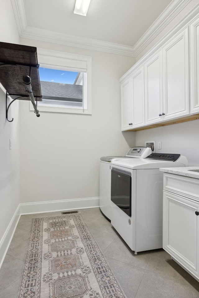 laundry room featuring light tile patterned flooring, cabinets, ornamental molding, and separate washer and dryer