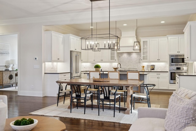 kitchen featuring appliances with stainless steel finishes, dark hardwood / wood-style flooring, pendant lighting, decorative backsplash, and white cabinets