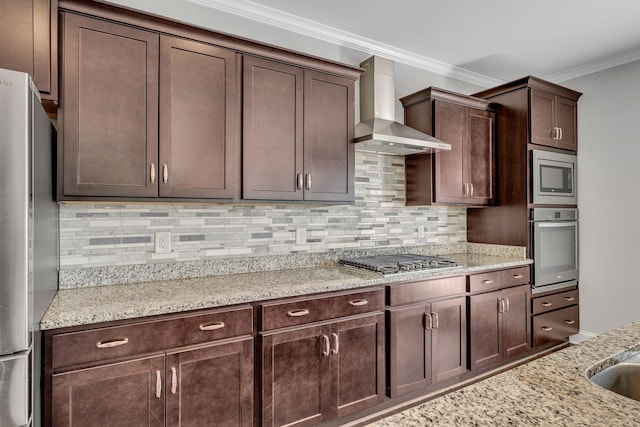 kitchen featuring crown molding, wall chimney exhaust hood, stainless steel appliances, and light stone countertops