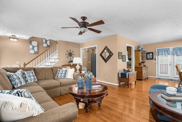 living room with ceiling fan, light hardwood / wood-style flooring, and a textured ceiling