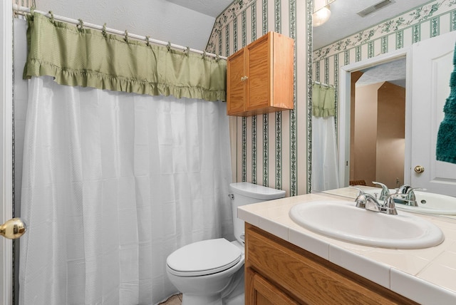 bathroom featuring vanity, toilet, and walk in shower