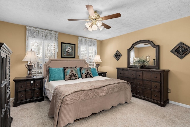 bedroom featuring ceiling fan, light carpet, and a textured ceiling