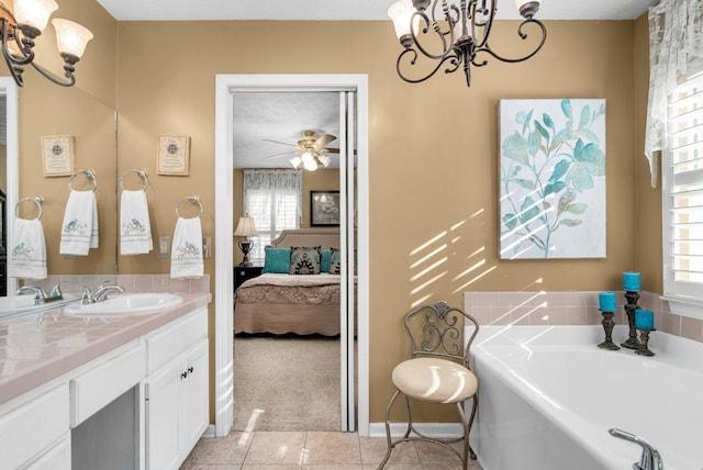 bathroom featuring tile patterned floors, a bath, ceiling fan with notable chandelier, and vanity