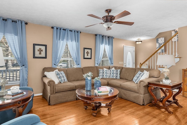 living room with ceiling fan, plenty of natural light, light hardwood / wood-style flooring, and a textured ceiling