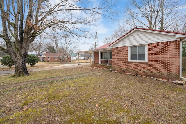 view of side of home with a carport and a yard