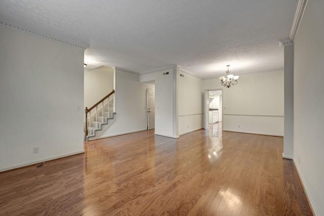 spare room featuring hardwood / wood-style flooring, ornamental molding, and a textured ceiling