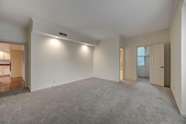 carpeted spare room featuring crown molding