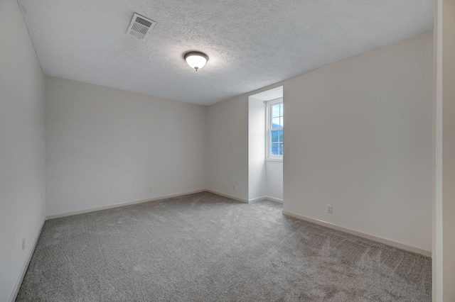 unfurnished room with light carpet and a textured ceiling