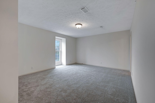 carpeted spare room with a textured ceiling