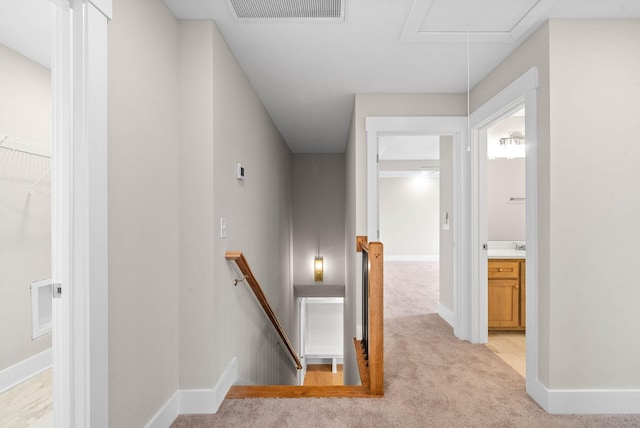 stairs with carpet floors, attic access, visible vents, and baseboards