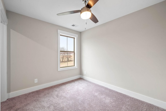 empty room with a ceiling fan, carpet flooring, visible vents, and baseboards