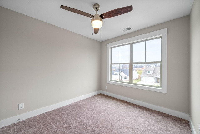 carpeted empty room with visible vents, ceiling fan, and baseboards