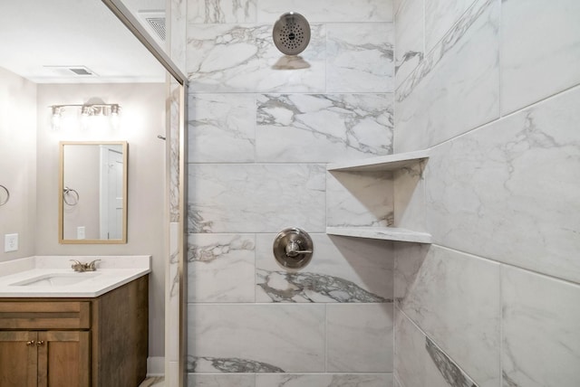 full bathroom with visible vents, tiled shower, and vanity