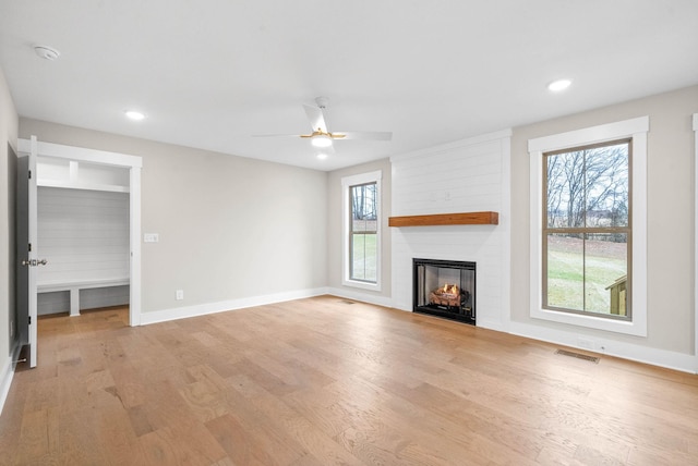 unfurnished living room with recessed lighting, a fireplace, visible vents, baseboards, and light wood-style floors