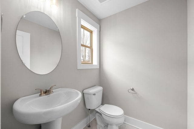 bathroom with baseboards, a sink, visible vents, and toilet