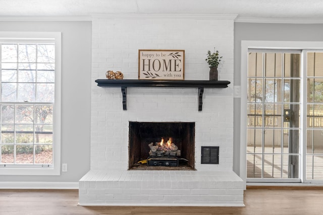 interior details featuring ornamental molding, hardwood / wood-style floors, and a brick fireplace