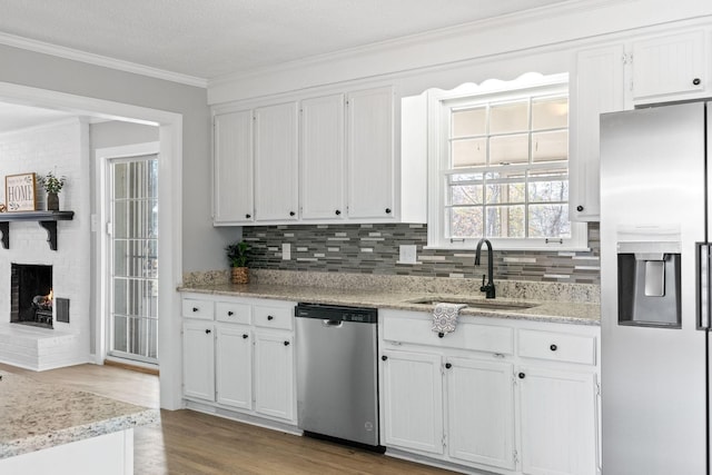 kitchen with crown molding, stainless steel appliances, sink, and white cabinets