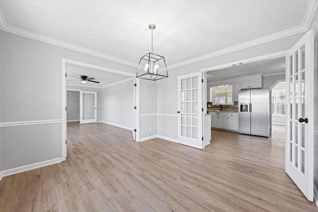 unfurnished dining area featuring sink, crown molding, light hardwood / wood-style floors, and french doors