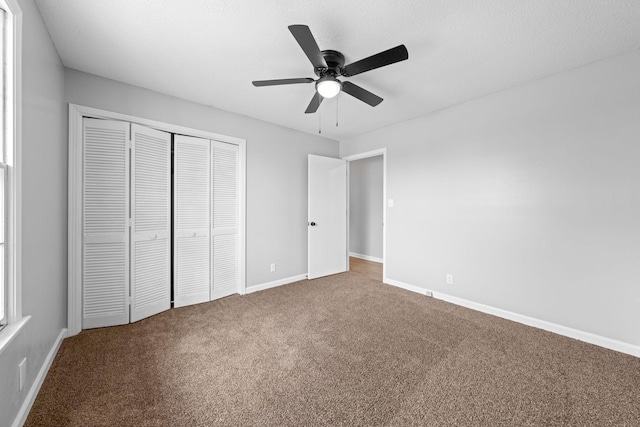 unfurnished bedroom with ceiling fan, carpet floors, and a closet