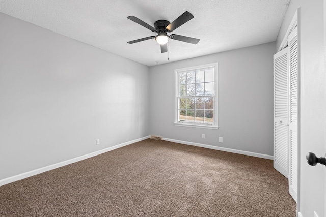 unfurnished bedroom featuring ceiling fan, carpet floors, a closet, and a textured ceiling