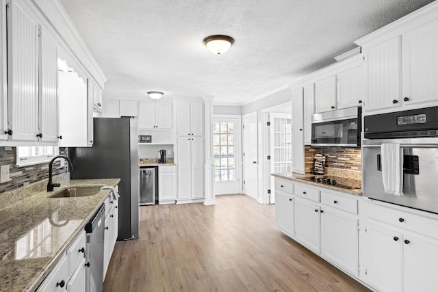 kitchen featuring white cabinetry, sink, stainless steel appliances, light stone countertops, and light hardwood / wood-style flooring