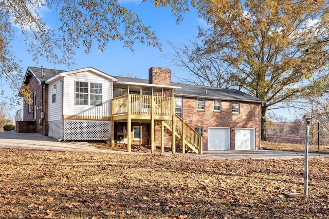 rear view of house with a garage and a sunroom