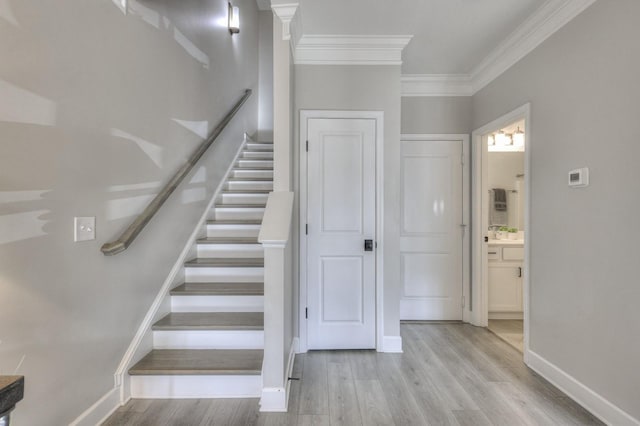 stairs with ornamental molding and hardwood / wood-style floors