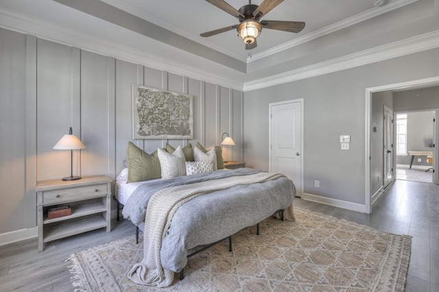 bedroom with ceiling fan, ornamental molding, and wood-type flooring