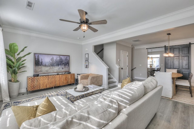 living room featuring crown molding, ceiling fan with notable chandelier, and hardwood / wood-style floors