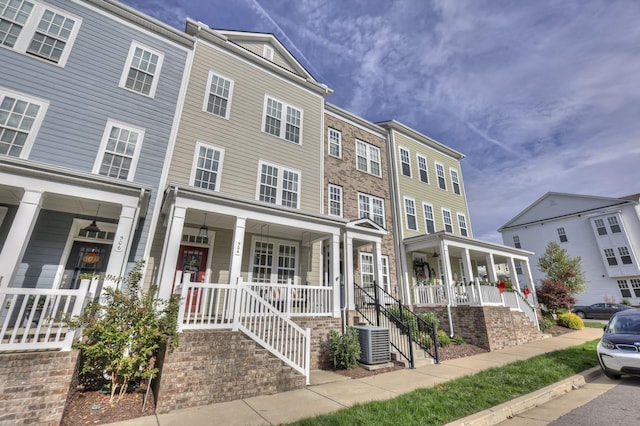 townhome / multi-family property with cooling unit and covered porch