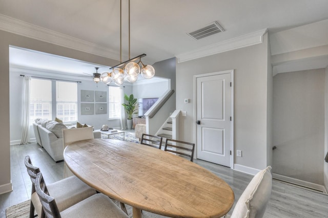 dining space with ceiling fan, ornamental molding, and light wood-type flooring