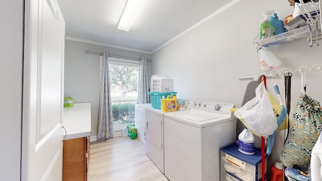 laundry area featuring ornamental molding, washer and dryer, and light wood-type flooring