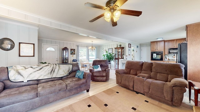 living room featuring ornamental molding, ceiling fan with notable chandelier, and light hardwood / wood-style floors