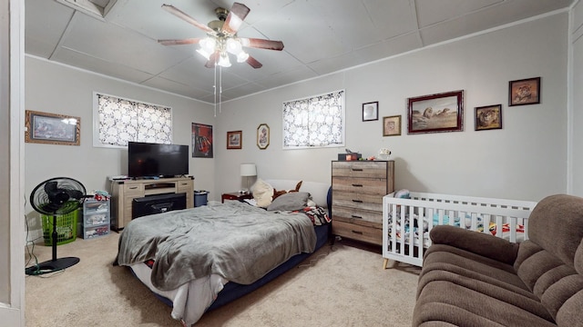 bedroom with ornamental molding, light colored carpet, and ceiling fan