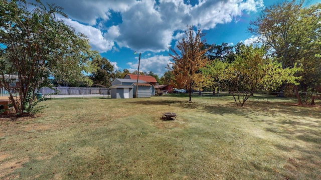 view of yard with a storage shed and an outdoor fire pit