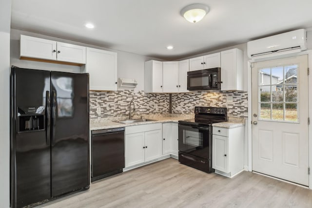 kitchen featuring white cabinetry, sink, and black appliances