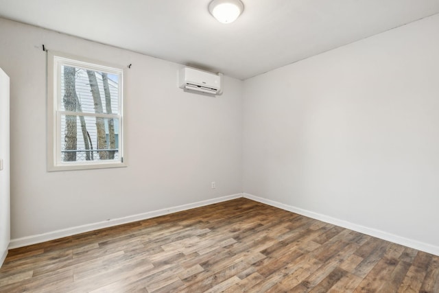 empty room featuring a wall unit AC and wood-type flooring