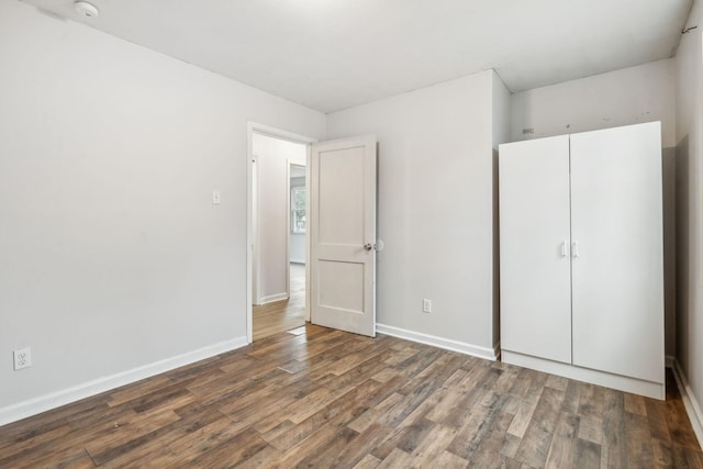 unfurnished bedroom featuring dark wood-type flooring and a closet