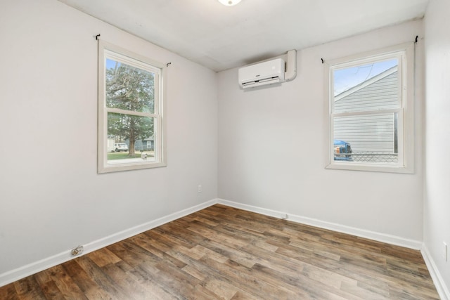 empty room with an AC wall unit and wood-type flooring