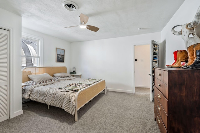 bedroom with ceiling fan, light carpet, and a textured ceiling