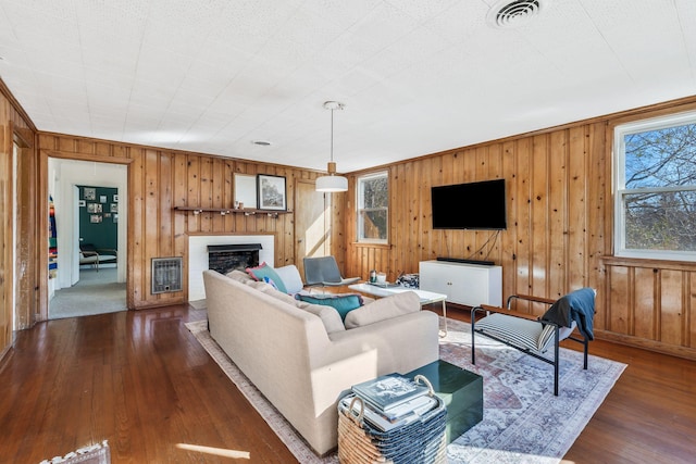 living room with dark hardwood / wood-style floors, a fireplace, and heating unit