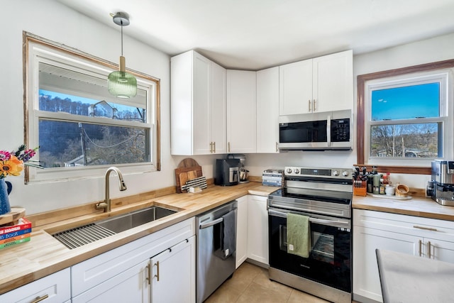 kitchen featuring white cabinetry, appliances with stainless steel finishes, sink, and pendant lighting