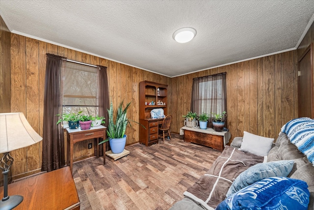 home office with ornamental molding, hardwood / wood-style floors, a textured ceiling, and wood walls