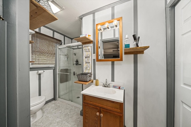 bathroom with vanity, toilet, and a shower with door