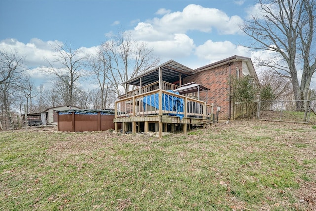 rear view of property with a pool side deck and a lawn