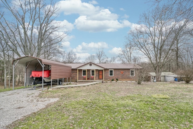 view of front facade featuring a carport, a storage shed, covered porch, and a front lawn